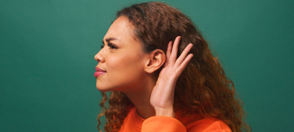 woman with musical ear syndrome putting hand up to ear